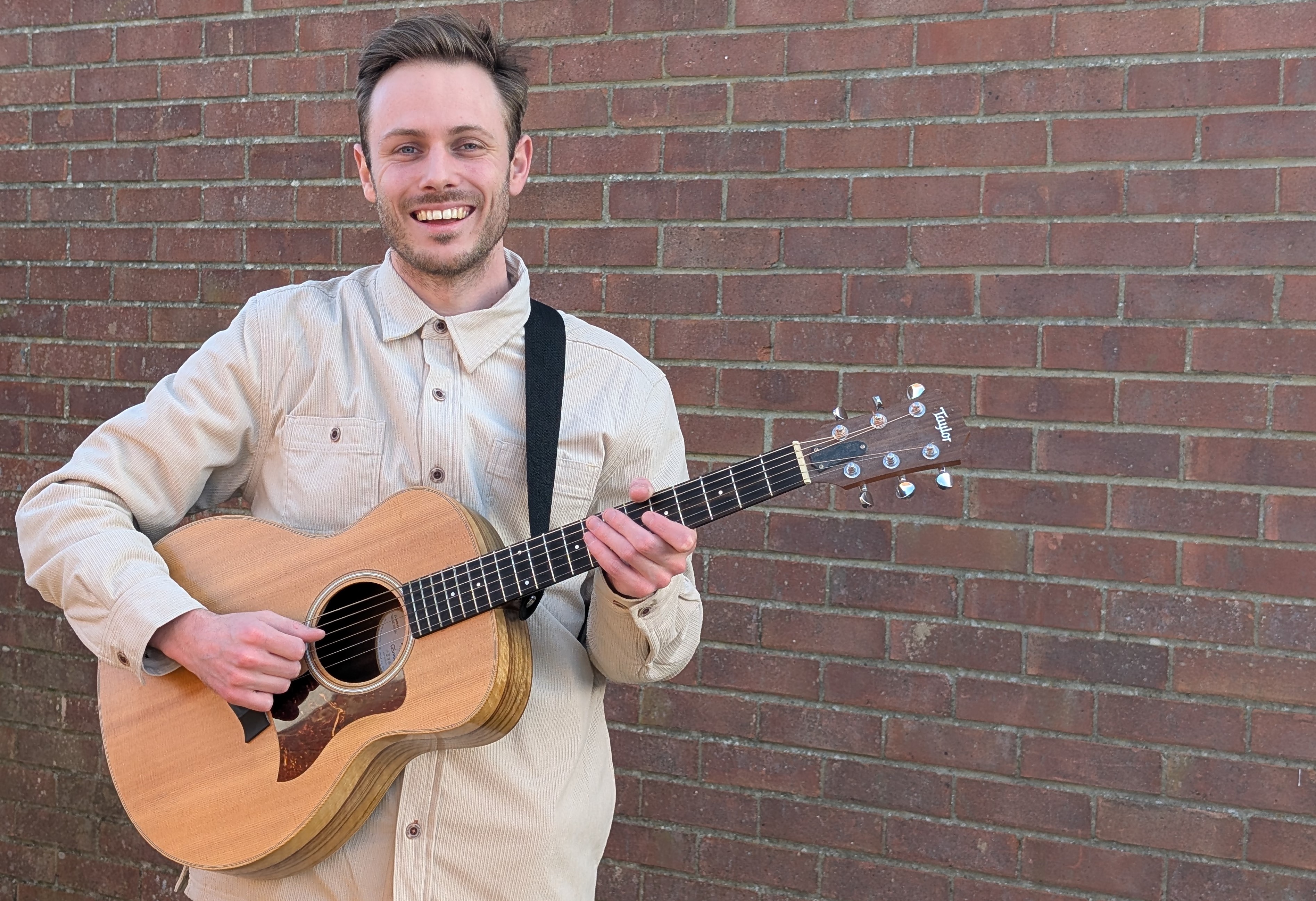 George Capon holding an acoustic guitar